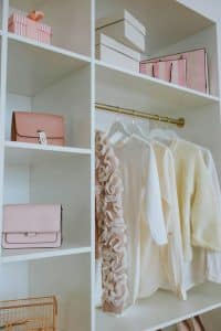 White open closet with neatly arranged clothing, handbags, and storage boxes — part of a professional home organization project in Atlanta.
